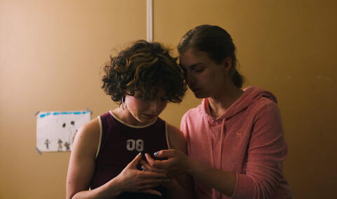 Zwei junge Frauen schauen gemeinsam auf ein Handy