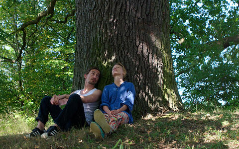 Mann und Frau sitzen unter einem Baum