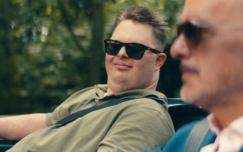 Zwei Männer mit Sonnenbrille sitzen in einem Cabrio