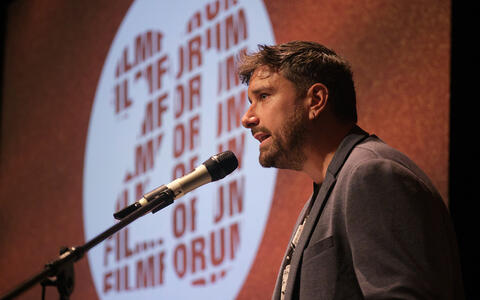 Ein Mann steht am Mikrofon