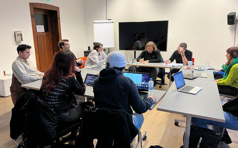 Das Foto zeigt die Kursleiter Elmar Freels und Magnus Vattrodt im Seminar mit den Drehbuchstudierenden aus dem BA Film.