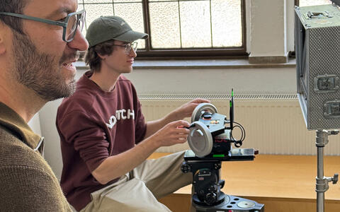 Student arbeitet mit Kamera und sieht auf einen Bildschirm