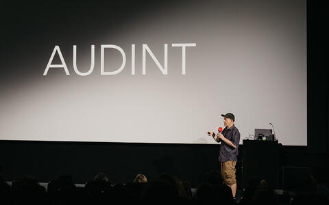 Keynote von Toby Heys auf der Bühne vor der Kinoleinwand
