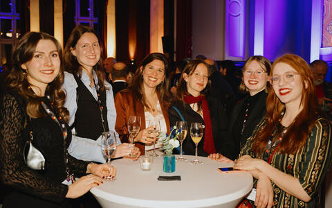 Sechs Teilnehmerinnen stehen beim NRW Empfang auf der Berlinale an einem Stehtisch.