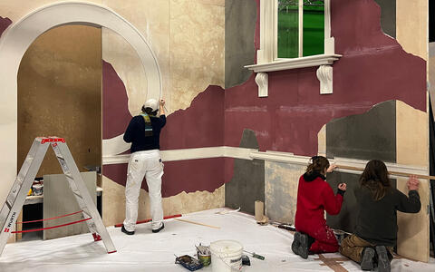 Szenenbildstudierende arbeiten im Studio an der Fassade eines Art-Deco-Hauses