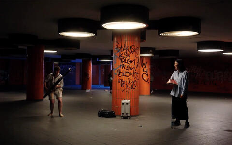 Zwei junge Menschen machen in einer Berliner U-Bahn Station Musik