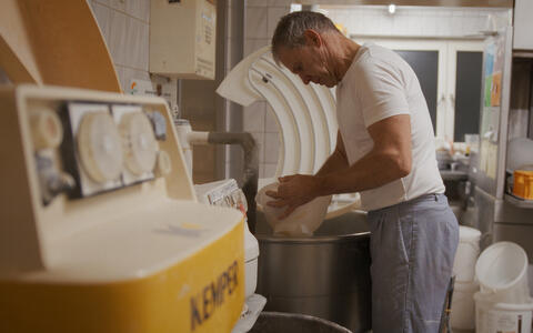 Ein Bäcler steht in einer Backstube