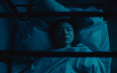 Akim liegt im Dunkeln im Bett