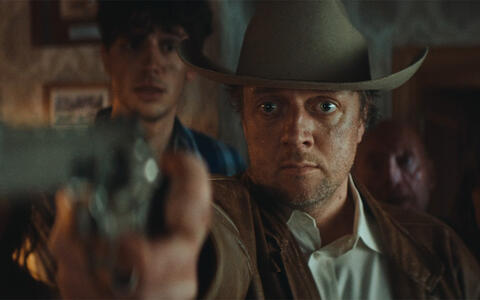 Ein Mann mit Cowboyhut und einer Pistole in der Hand