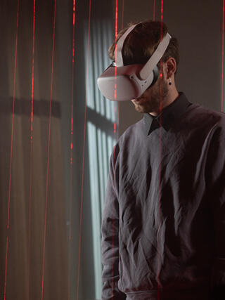 Student mit VR-Brille im ifs-Studio bei Dreharbeiten