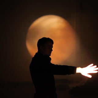 Schauspieler mit Hand vor Scheinwerferlicht