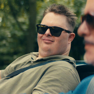 Zwei Männer mit Sonnenbrille sitzen in einem Cabrio